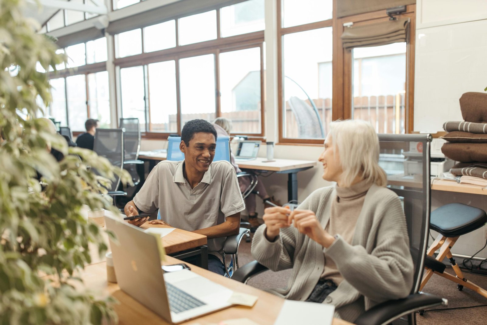 Diverse team collaborating in a creative office setting, showcasing teamwork and smiling expressions.